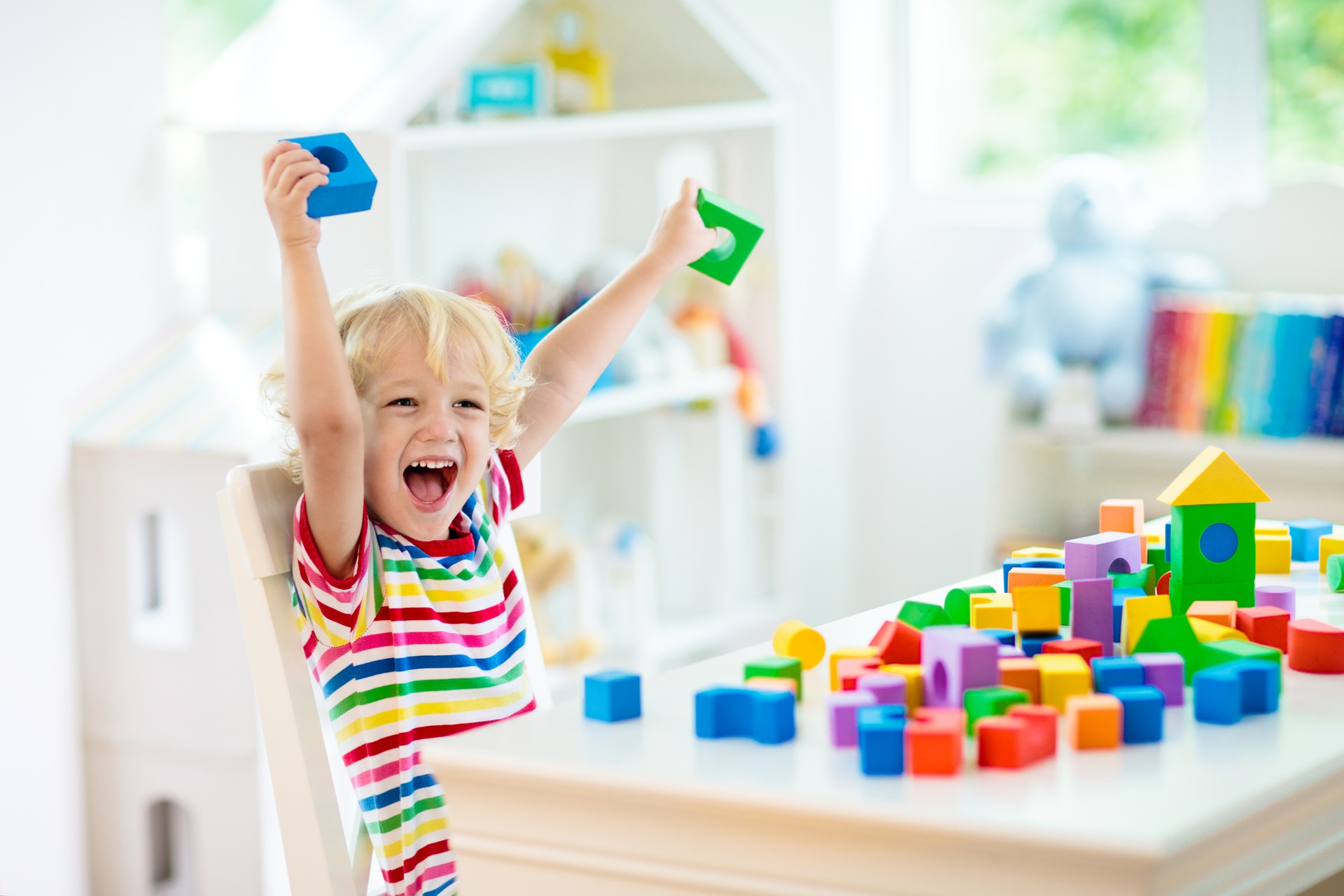 Kids toys. Child building tower of toy blocks.